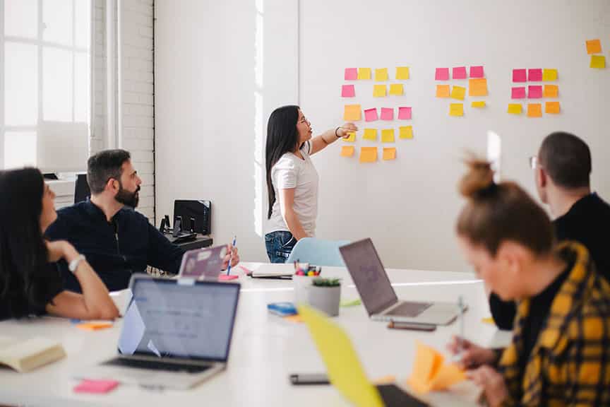 Photo d'une réunion avec des post-it colorés sur un mur